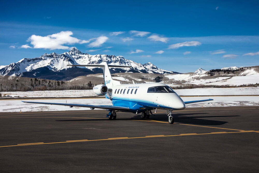 PlaneSense PC-24 jet in front of snow-covered mountains. 