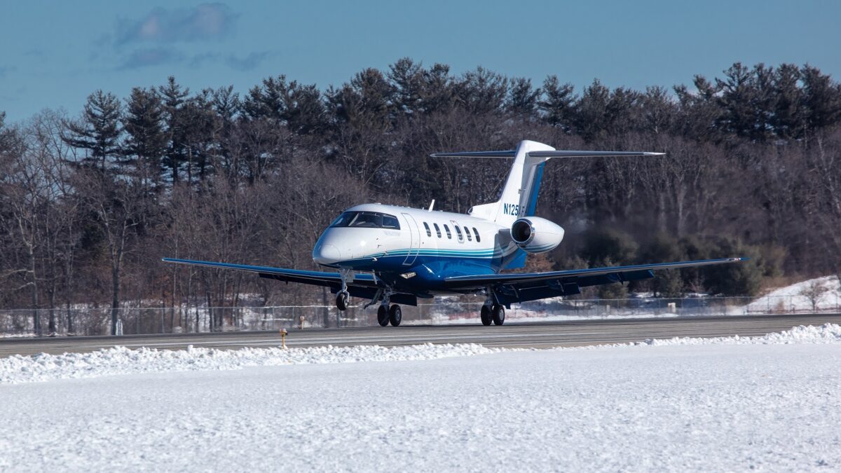 PlaneSense PC-24 jet landing on snowy runway.