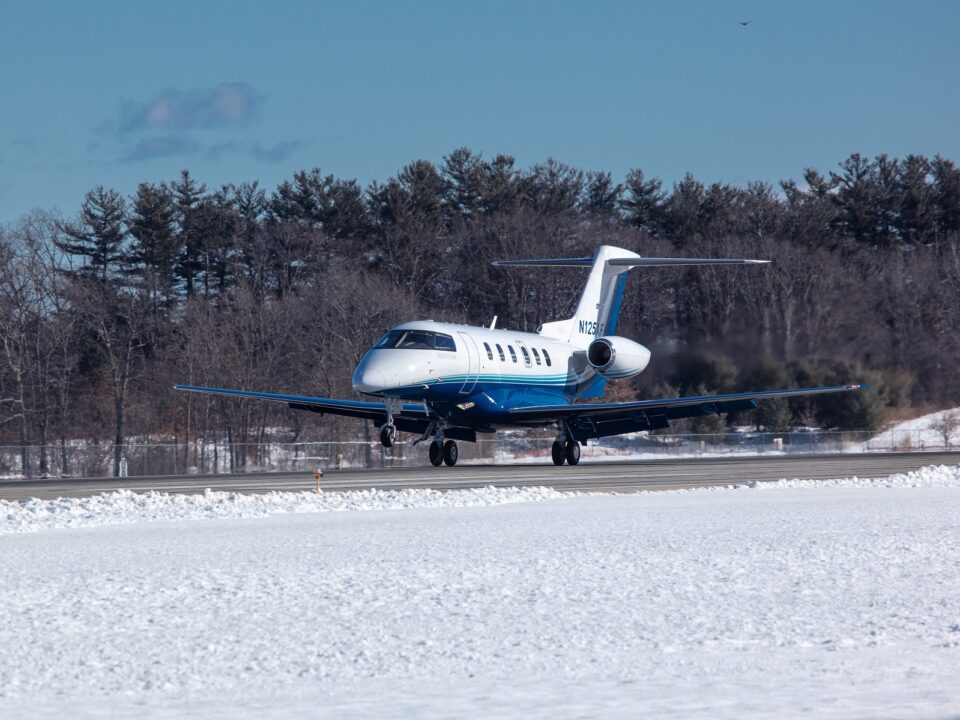 PlaneSense PC-24 jet landing on snowy runway.
