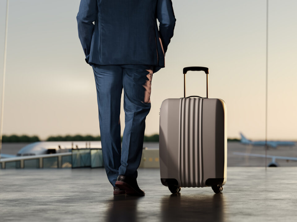 Travel concept background. Businessman with suitcase at airport